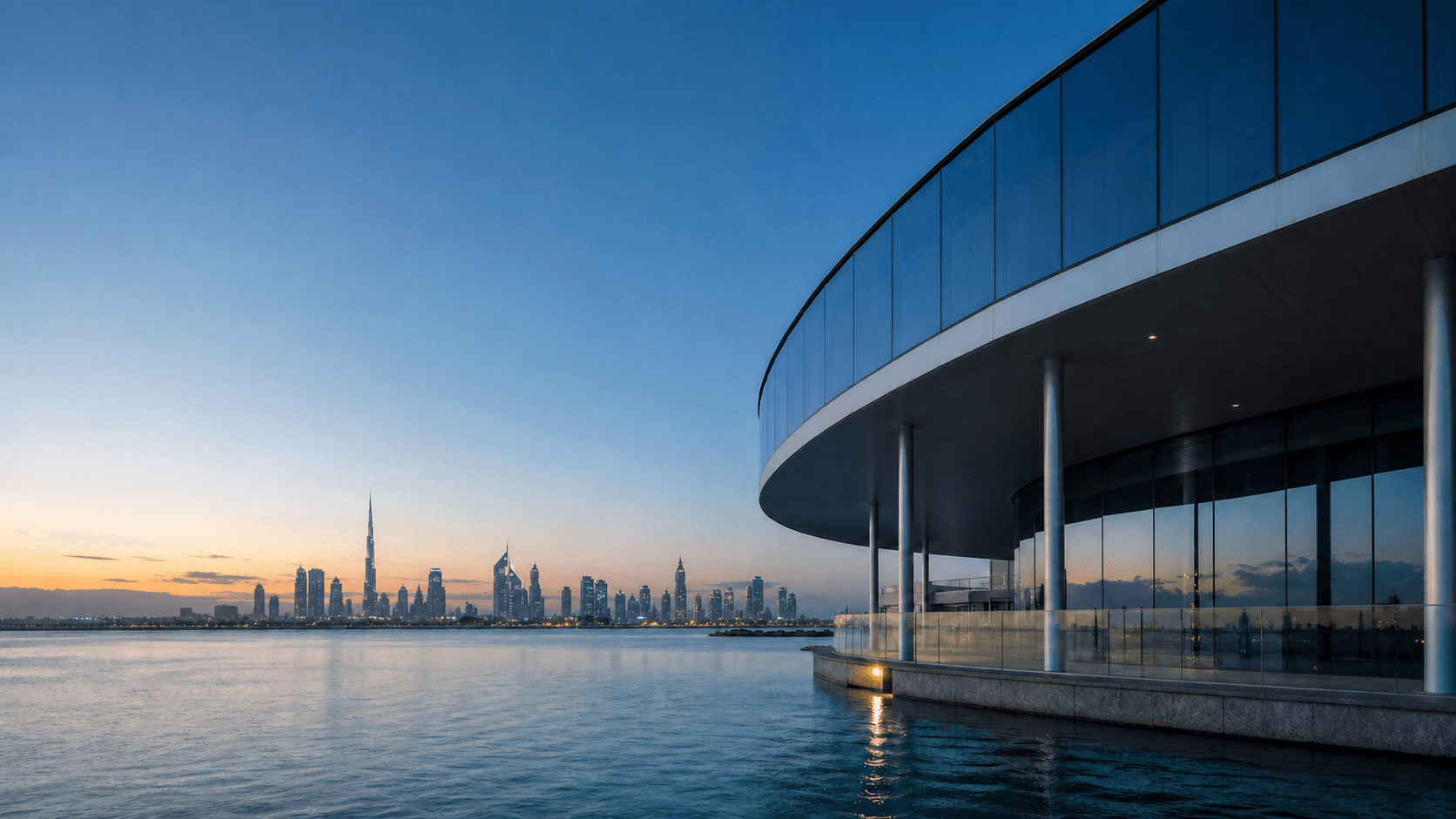 Dubai waterfront and a refined blue glass building at dusk